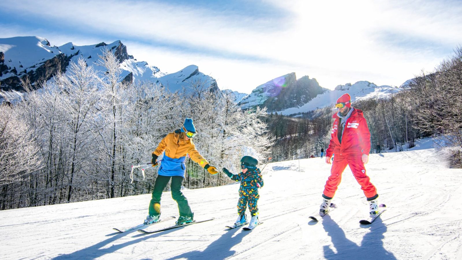 Une maman et son enfant descendant la piste verte de La Balade à Gourette accompagnés d'un moniteur de ski de l'ESF