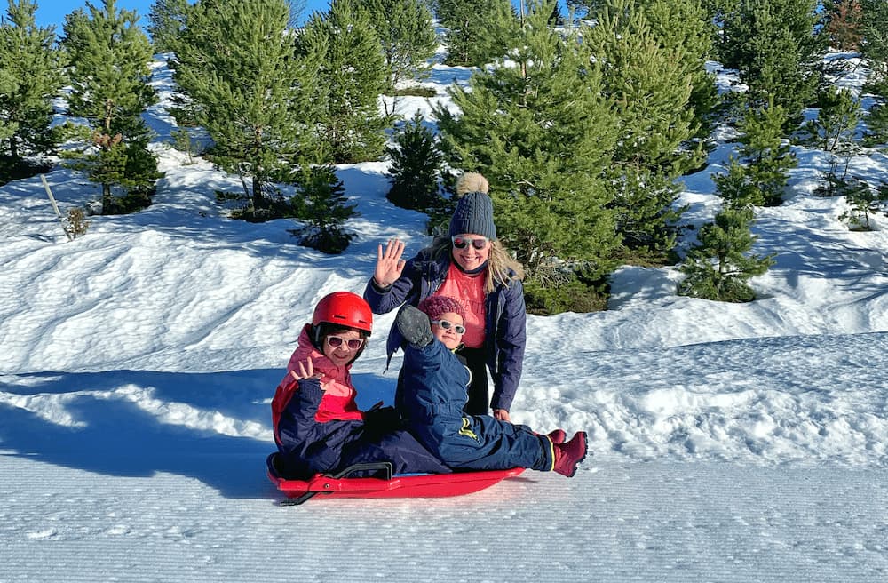 Une famille avec deux enfants sur la piste de luge à Gourette