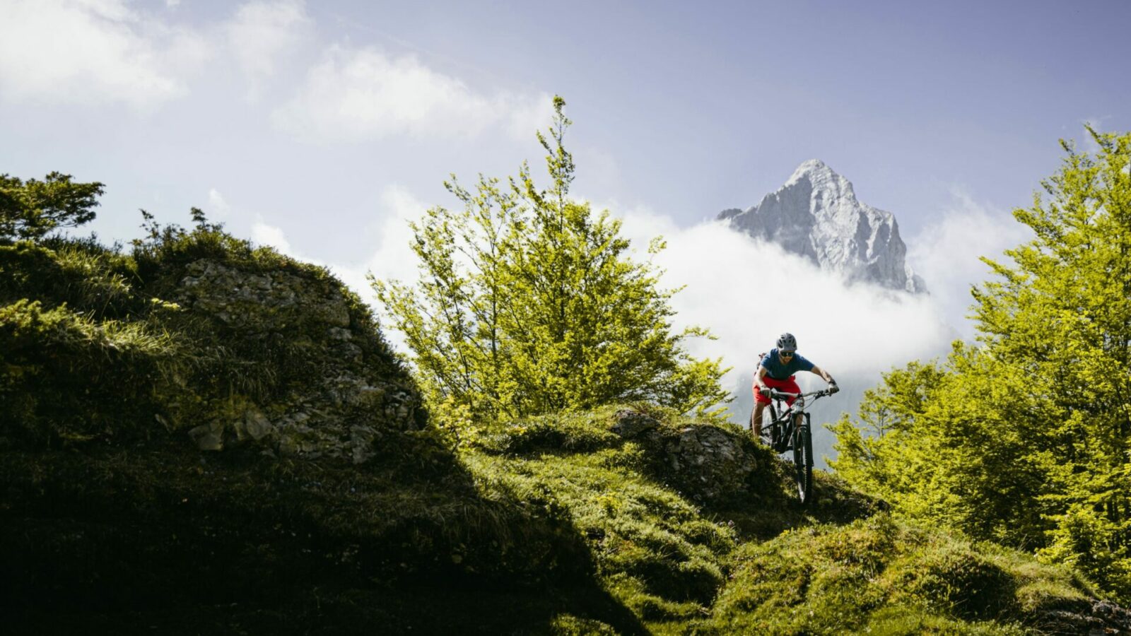 Vététiste dans un passage délicat sur le Bik Park de Gourette en Vallée d'Ossau dans les Pyrénées. En fond le Pène Médaa.